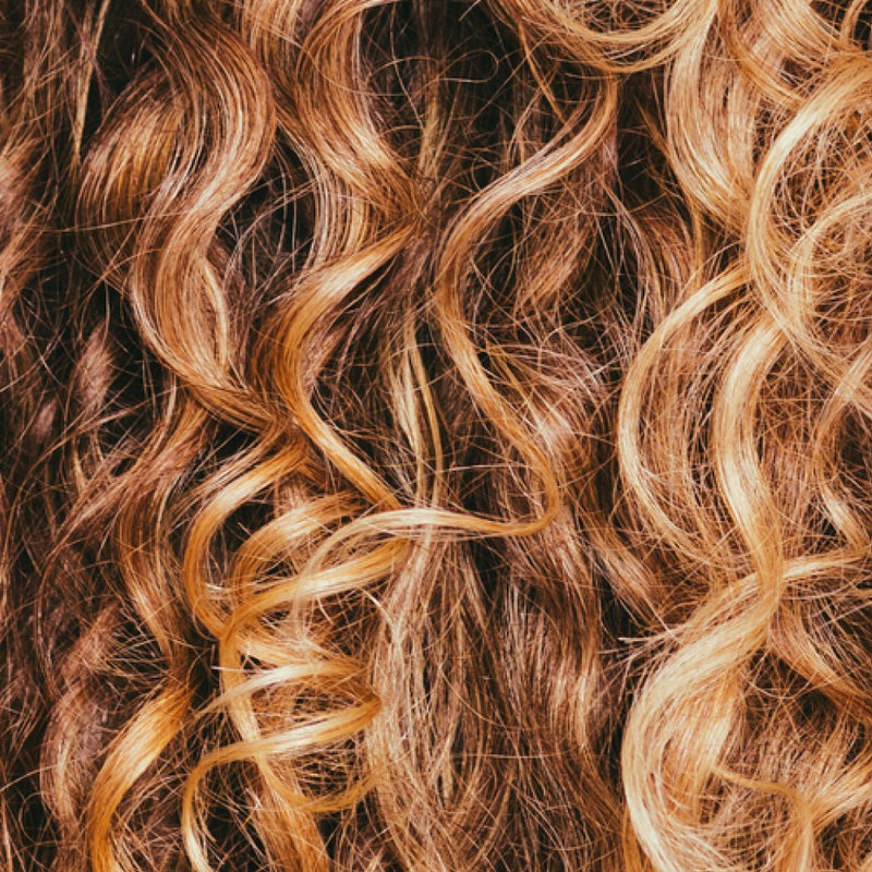 Close-up of wavy hair with brown and blonde tones.