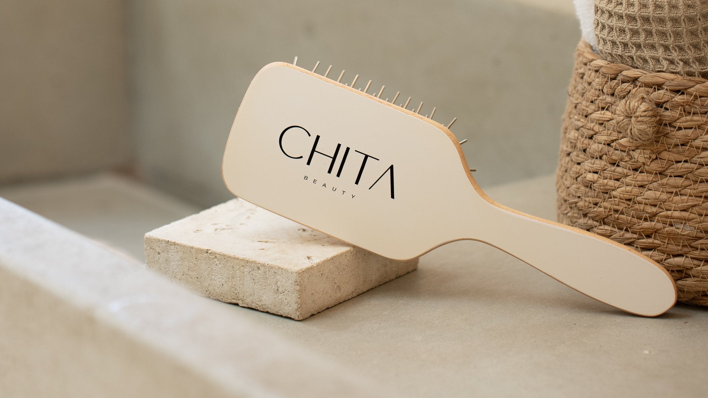 Wooden hairbrush with 'CHITA' branding on a neutral background